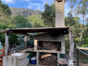 an outdoor pizza oven with a wooden roof at Damiro in Piriápolis