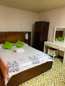 - une chambre avec un lit doté d'oreillers verts et d'un bureau dans l'établissement Hotel La Estrella de la Mañana, à Tuluá