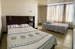Habitación de hotel con 2 camas y mesa en Hotel La Estrella de la Mañana en Tuluá