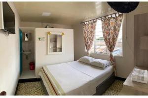 Habitación pequeña con cama y ventana en Hotel La Estrella de la Mañana en Tuluá