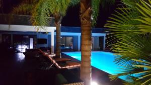 een zwembad met palmbomen voor een huis bij Villa droena in Carrazedo