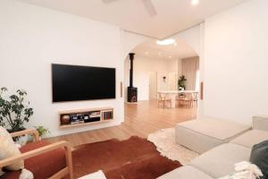 a living room with a flat screen tv on a wall at Palm Springs in Port Lincoln! in Port Lincoln