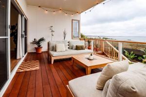 a living room with a couch and a table on a balcony at Palm Springs in Port Lincoln! in Port Lincoln