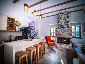 a kitchen with a counter with chairs and a fireplace at SELO Luxury Suite in Álli Meriá
