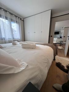 una camera da letto con un grande letto bianco e armadi bianchi di Appartement Hyper-Centre Megeve - ski à pied a Megève