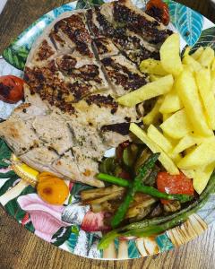 um prato de comida com carne e batatas fritas em El nido del Chorro em Málaga