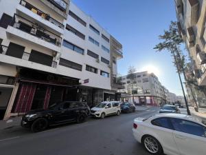 uma rua com carros estacionados em frente aos edifícios em Rabat-Agdal, Modern & Spacious Apartment at StayInMoroccoVibes em Rabat