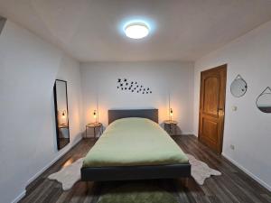 een slaapkamer met een bed en twee lampen aan de muur bij Appartement Luna in Dinant