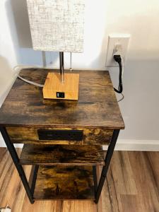 a wooden table with a lamp on top of it at LittleBettysCrashPad in Torrance