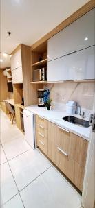 una cocina con armarios de madera y fregadero en Estudio Em Itaipava - Granja Brasil - Flat Luxo - Com Piscina Aquecida, en Itaipava