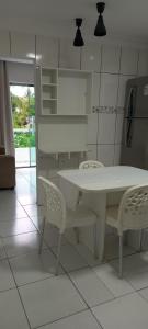 a kitchen with a white table and two chairs at Casa acessível in Dias dʼÁvila