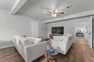 a living room with two white couches and a ceiling fan at Modern Gem: SeaWorld, Base & DT in San Antonio