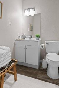 a white bathroom with a sink and a toilet at Steps to Lackland AFB & SeaWorld in San Antonio