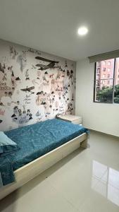 卡利的住宿－Apartamento en segundo piso Zafiro C, Valle del Lili.，一间卧室配有一张床和一个带贴纸的墙壁