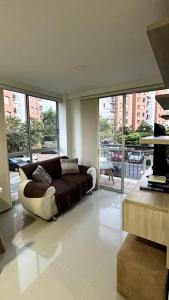 a living room with a couch and a large window at Apartamento en segundo piso Zafiro C, Valle del Lili. in Cali