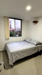 a bedroom with a large bed with a window at Apartamento en segundo piso Zafiro C, Valle del Lili. in Cali