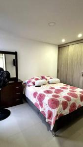 a bedroom with a bed with a dresser and a mirror at Apartamento en segundo piso Zafiro C, Valle del Lili. in Cali