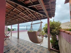 een hangmat hangend aan een pergola op een patio bij Uma jóia em frente ao mar! in Piúma
