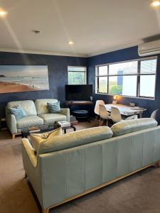 a living room with a couch and a table at Beach Apartment in Papamoa