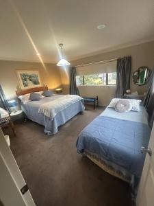 a bedroom with two beds and a window at Beach Apartment in Papamoa