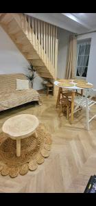 uma sala de estar com uma mesa e uma escada em LaMaisonnette 500m plage Juno Beach em Bernières-sur-Mer