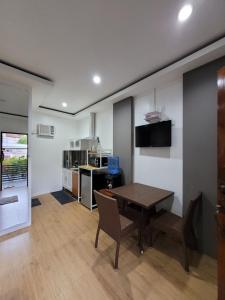 a room with a table and chairs and a kitchen at La Belle Staycation in Puerto Princesa City