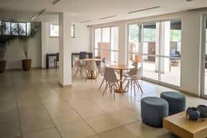 Habitación grande con mesas, sillas y ventanas. en Nosso Apê Estrela Sul: Ar-condicionado | Garagem NA0207 en Juiz de Fora