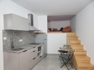 a kitchen with white cabinets and a counter top at Romantic Studio in Vila do Conde
