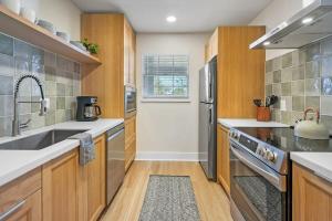 une cuisine avec des armoires en bois et des appareils en acier inoxydable dans l'établissement Fido Friendly Condo Sun and Fun Walk to DT Free Parking, à Saint Augustine