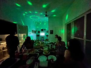 um grupo de pessoas sentadas em torno de uma mesa com luzes verdes em Mangroves & Sandbar Private Resort em Calatagan
