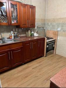 a kitchen with wooden cabinets and a sink and a stove at عباس العقاد in Cairo