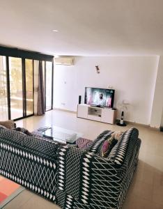 a living room with a couch and a tv at Bella casa in Dakar