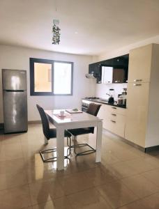 a kitchen with a table and chairs and a refrigerator at Bella casa in Dakar