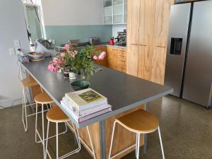 un bancone cucina con tavolo, libri e fiori di Stunning Views over Tasman Bay a Nelson