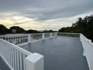 una terraza blanca con una valla blanca y árboles en Mangroves & Sandbar Private Resort en Calatagan