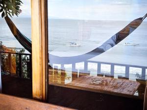 a view of the ocean from a window with a table at Malibu Huts in Nusa Penida