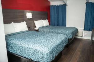 2 bedden in een hotelkamer met blauwe lakens bij Econo Lodge Summit - Scranton in Clarks Summit