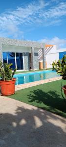 a swimming pool in front of a house with plants at Residência Águia in Praia