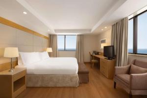 um quarto de hotel com uma cama, uma secretária e uma cadeira em Hilton Copacabana Rio de Janeiro no Rio de Janeiro