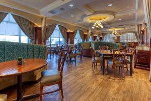 un restaurant avec des tables, des chaises et des fenêtres dans l'établissement Drury Plaza Hotel St. Louis Chesterfield, à Chesterfield