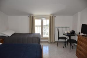 Schlafzimmer mit einem Bett, einem Tisch und einem TV in der Unterkunft Monte Cucco B&B in Scheggia e Pascelupo