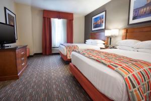 a hotel room with two beds and a flat screen tv at Drury Inn & Suites Columbus Grove City in Grove City