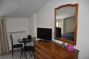 Schlafzimmer mit einem Schreibtisch, einem TV und einem Spiegel in der Unterkunft Monte Cucco B&B in Scheggia e Pascelupo