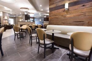 um restaurante com cadeiras e mesas num quarto em Drury Inn & Suites Louisville North em Louisville