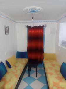 a room with two beds and a red curtain at The little house in Chefchaouen