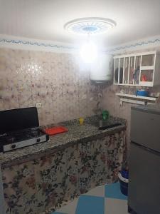 a kitchen with a counter with a television and a refrigerator at The little house in Chefchaouen