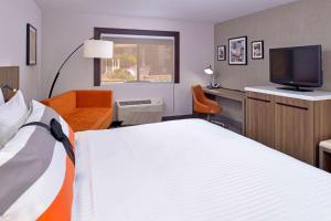 um quarto de hotel com uma cama e uma televisão em La Casa Modesto, Ascend Hotel Collection em Modesto