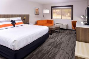 ein Hotelzimmer mit einem Bett und einem Stuhl in der Unterkunft La Casa Modesto, Ascend Hotel Collection in Modesto