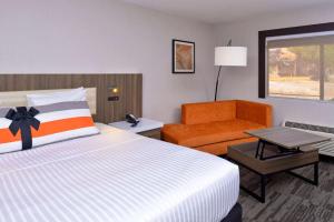 um quarto de hotel com uma cama e uma cadeira em La Casa Modesto, Ascend Hotel Collection em Modesto