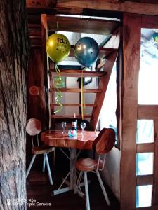 una mesa con dos globos y dos copas de vino en Cabaña en el Árbol La Calera, en La Calera